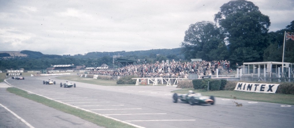 A group of people watching a race car go around a track

Description automatically generated with low confidence